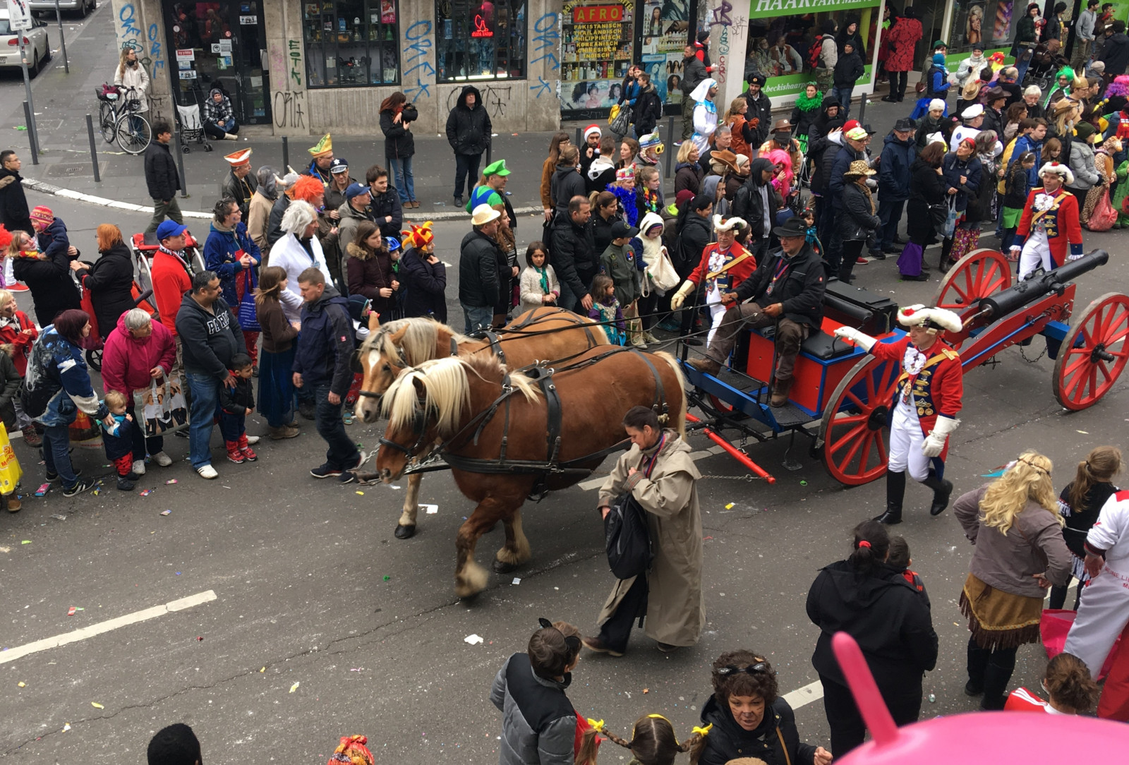 Pferde im Rosenmontagszug ziehen eine Kutsche mit Konfettikanone
